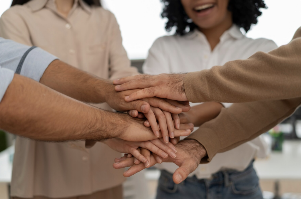 Imagem com quatro pessoas — dois homens e duas mulheres — simbolizando a construção de um ambiente corporativo respeitoso, diverso e acolhedor, onde mulheres se sentem seguras e valorizadas.
