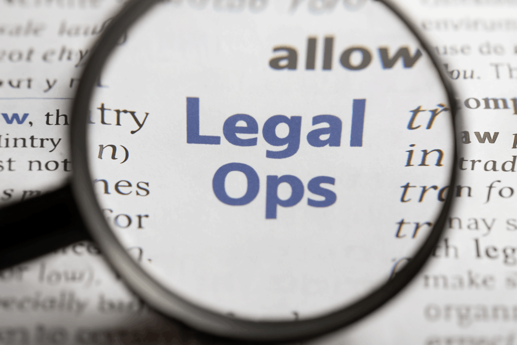 Livro aberto com várias palavras impressas, em que uma lupa amplia especificamente a palavra “legal”. A imagem representa o foco estratégico do Legal Ops em bancos, destacando a importância da gestão jurídica eficiente, da automação de processos e da conformidade no setor financeiro. Ilustra visualmente como a tecnologia e os dados jurídicos aprofundam a análise legal para aumentar a produtividade, reduzir riscos e otimizar custos nas instituições financeiras.